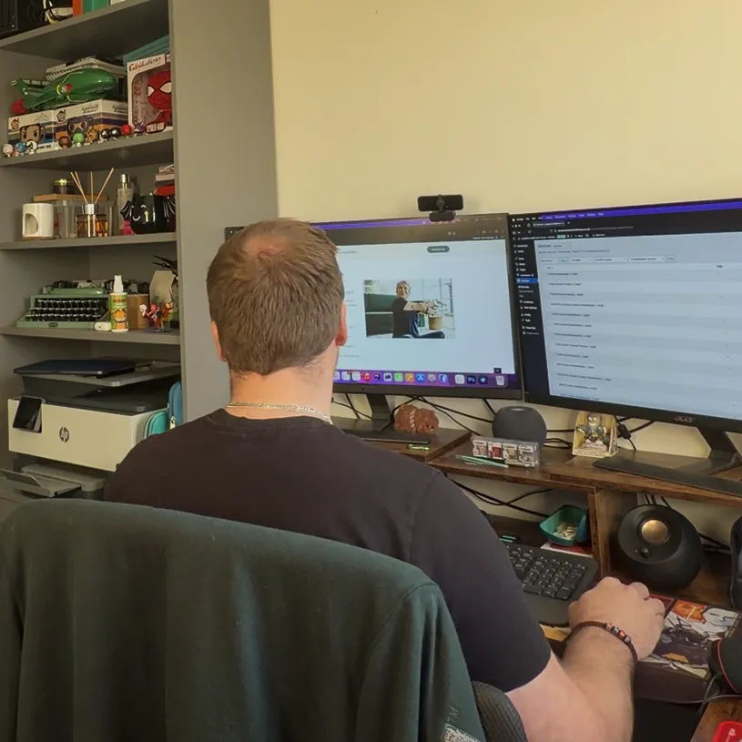 Tom sat at a desk with his back to the camera